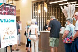 Guests gather at the desk to tour Astral at Auburn senior living community