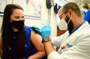 Image of woman getting vaccination from male pharmacist