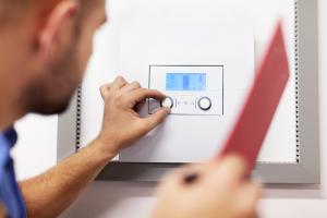 Technician adjusting settings on tankless water heater