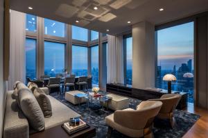 The space opens to an inviting and expansive area perfect for entertaining, with a double-story wall of windows and the beautiful city stretching beyond them.