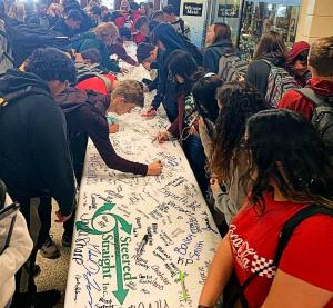 Youth at a Steered Straight presentation sign a pledge to live drug-free lives.