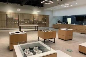Image of a beautifully built interior for a cannabis dispensary, with high cement ceilings and wooden sound fixtures on the cement walls.