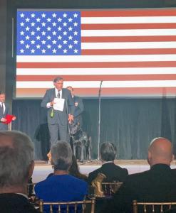 Chris and his Service Dog Brit stand on stage to accept the 2021 VETTY Award