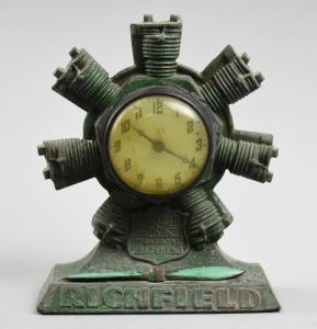 Circa 1920 Richfield Oil promotional desk clock with an aviation theme. Designed by Curtiss, in the shape of an airplane engine. Estimate: $250-$500.