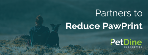 PetDine advertisement showing the back of a woman and dog sitting on a mountain with headline saying, "Partners to Reduce PawPrint" and PetDine Made Better logo.