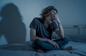 Patient anguished, sitting on bed