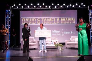 Steven G presents Dorothy Gurowitz scholarship check to Makaela Odom as Embrace Girls Foundation Founder and CEO Velma Lawrence looks on.