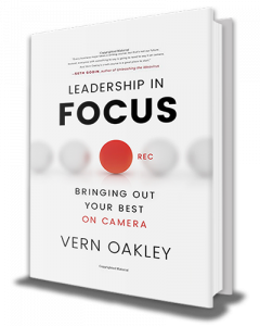 A white book with black text that reads "Leadership in Focus: Bringing Out Your Best On Camera," written by Vern Oakley. There is a red circle in the center with the text "rec" to mimic a recording light on a camera.