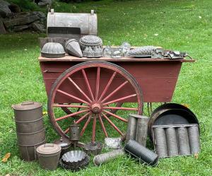 Colonial cookware and other metal wares, plus an antique wagon.