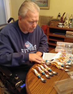 Ken Vantroba at his dinning room table customizing his Cuddle Spoons for customers.