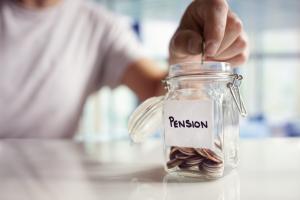 Hand putting money into a jar labelled pension