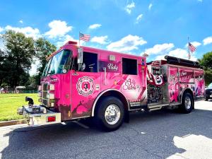 A pink fire engine with the message on the side You will Never Fight Breast Cancer Alone