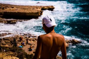 Man walking towards Bondi Beach wearing a Ralph Lauren hat