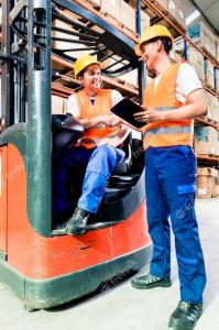 A warehouse worker being trained on how to operate a forklift