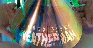 weatherman album artwork including a person behind the iridescent mask looking at the camera