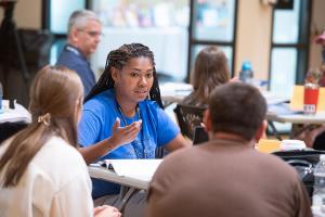 Educators talk together around a table.