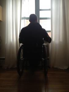 man in wheelchair at window