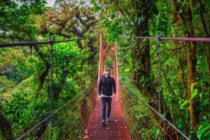 Matt  Keezer walking on a bridge in costa Rica