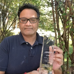 Sanjay Shrivastava holds up his crystal Andrus Award.