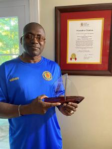 Curtis Jones poses with his AARP Maryland State President's Award, a crystal shaped like a sailboat.