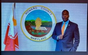 Calvin Ball stands in front of the Howard Co. Seal to offer his congratulations.