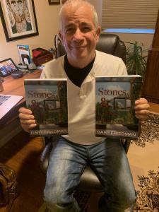 Gary Friedman, author, holds up his latest book, Stones and Glass Houses