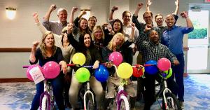 A team poses with bikes they built together in TeamBonding's Charitable Bike Build activity.