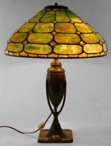 Early 20th century leaded green glass table lamp, boasting a geometric shaped green marbled glass panel lampshade over an openwork bronze column, overall ($13,750).