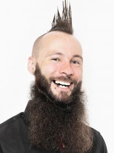 White man in his 30s with a brown mohawk and beard