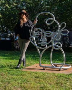 Artist Alice Mizrachi with her "Renaissance Women" sculpture in Marcus Garvey Park.  Photo by Christelo Gerard.