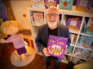 Best-Selling Author Peter H. Reynolds Holds His New OUR TABLE Storybook.