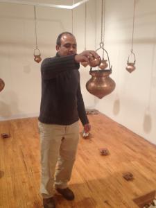 Viewer pouring water into the Anti-Sikh Pogrom "dharapatra" in Memory Leaks by Pritika Chowdhry