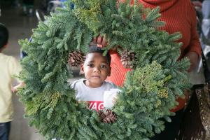 little boy in wreath at the JADV toy and gift giveaway