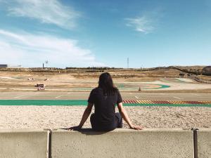 Ellis sits on the pit wall with his back to the camera overlooking the Aragon track
