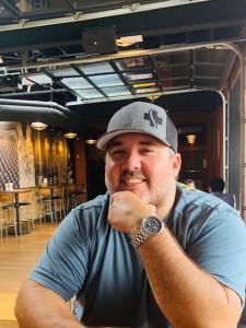 A young man wearing a hat seated in a cannabis provisioning store