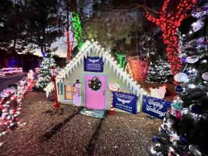 A house decorated with lights, snowmen, and icicles is the Anthem Injury Lawyers Display at Magical Forest