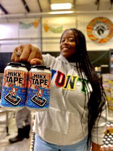 A woman holding a pack of Mikx Tape