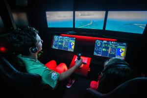 National Flight Academy students learning how to fly aircraft in a virtual flight simulator on board the USS Ambition.
