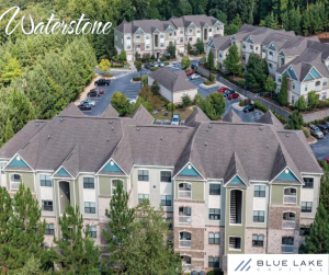 Large apartment complex surrounded by lush green trees