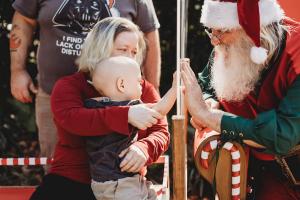 A young child and Santa reach toward each other during Edmarc Santa Run.