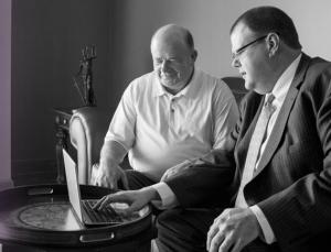 An attorney sits with a client showing him something on a laptop. Firmidable began providing professional-grade law firm marketing for Social Security Disability lawyers 30 years ago.