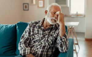 A man sits back on a couch, rubbing his eyes. People can get help meeting Social Security's strict definition of "disability" from disability attorneys like Geary Disability Law in Wisconsin.