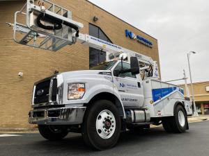 Image of a National OnDemand placer bucket truck parked beside National OnDemand headquarters in Burlington, NC.