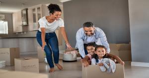 Multi-ethnic family smiling and moving into new home