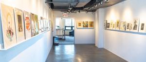 Rows of original art work installed on shelving at art gallery