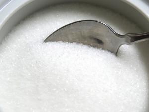 A cup of white sugar, teaspoon inserted