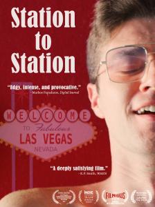 A young man laughs, lying on a red background with a faded "Welcome to Las Vegas" sign in the background.