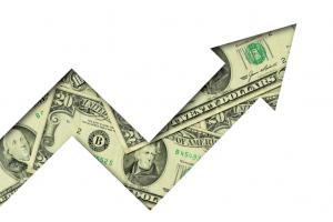 Upward arrow made of dollar banknotes on white background