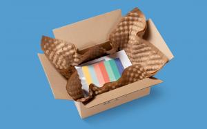 An image of a box on a blue background, using PAPERbubble® as void fill to pack and protect a shipment.