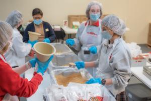 Bishop Kelley High School students lend a hand by packaging healthy meals for those suffering from food insecurity.